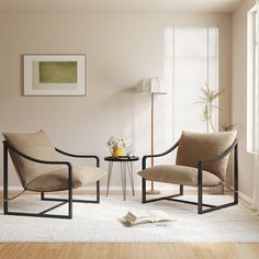 a living room with two chairs and a table in front of a window on top of a rug