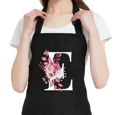 a woman wearing an apron with flowers on the front and letter g on the back