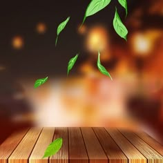 a wooden table topped with green leaves on top of a night sky filled with lights