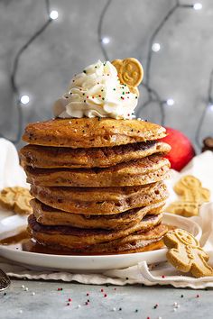 a stack of pancakes topped with whipped cream and cookies