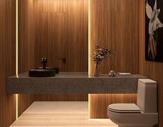 a bathroom with a toilet, sink and wooden wall paneling on the walls is lit by recessed lighting