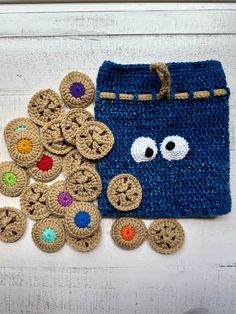 a crocheted bag with buttons and eyes next to it on a white surface