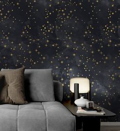 a living room with a couch, table and wallpaper that has gold stars on it