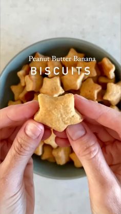 two hands holding small pieces of peanut butter banana biscuits in a blue bowl