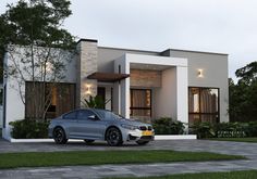 a silver car parked in front of a modern house with trees and grass around it