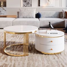 a white and gold coffee table sitting on top of a rug next to a couch