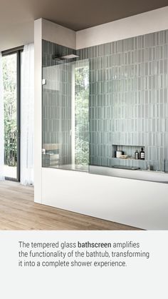 a bathroom with a glass bathtub and wooden floors