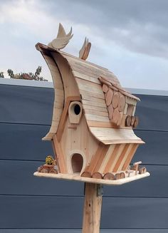 a bird house made out of wood on top of a pole