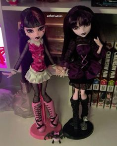 two dolls are standing next to each other