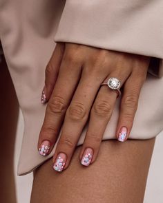 a woman's hand with pink and white flowers on it