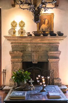 a living room with a fire place and paintings on the fireplace mantel above it