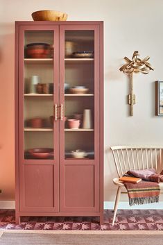 a red cabinet with glass doors in a room