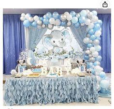 an elephant themed baby shower with blue and white balloons on the wall, cake table and decorations