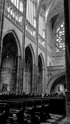 black and white photograph of the inside of a church with pews in front of it