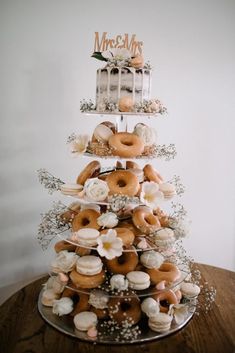 a tiered cake with donuts and flowers on it