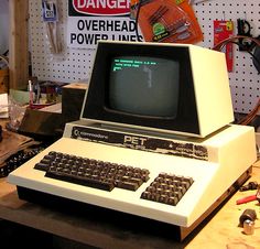 an old computer sitting on top of a table in a room with tools and other items