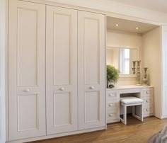 a bedroom with white closets and wooden floors in the corner, along with a large bed