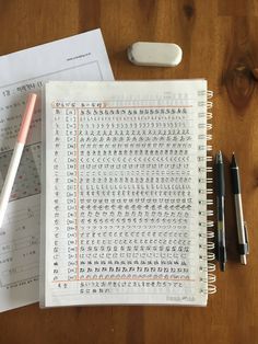 an open notebook with chinese writing on it next to a pen and calculator