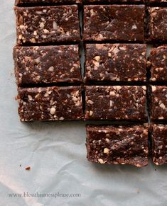 chocolate brownies cut into squares on a piece of parchment paper with walnuts in the middle