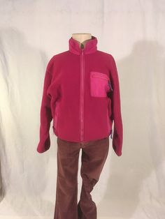 "vintage 1990s women's zip up fleece jacket Patagonia, made in USA 100% polyester trims -100% nylon 86% nylon, 14% spandex pink fuchsia w/purple trim zip up front/side pockets/breast pocket purple cordovan ribbon zipper pull tabs god vintage condition w/light wear zipper up front is a bit wavy (works fine) light wear fade on pocket trim (see photos) label size 10, see below measures, lying flat, shoulder-20\" chest-20 1/2\" sleeve-21\" hem-17 1/2\" to 19\" length-25\"     We do not offer returns Casual Pink Fleece Jacket With Pockets, Pink Fleece Jacket For Fall Sports, Casual Pink Fleece Jacket, Pink Fall Fleece Jacket For Sports, Pink Long Sleeve Fleece Jacket With Pockets, Pink Fleece Jacket With Pockets For Outdoor, Pink Outdoor Fleece Jacket With Pockets, Pink Fleece Outerwear With Pockets, Fitted Fleece Jacket For Outdoor