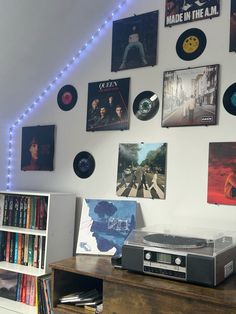 there are many records on the wall with lights around them and an old record player