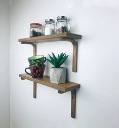 two wooden shelves with pots and mugs on them