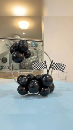 black balloons are stacked on top of each other in front of a blue table cloth