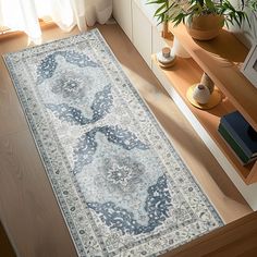 a large blue rug with an intricate design on the floor in front of a window