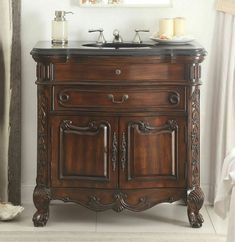 a bathroom vanity with an antique style sink and mirror on the wall next to it