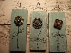 three wooden plaques with metal flowers on them