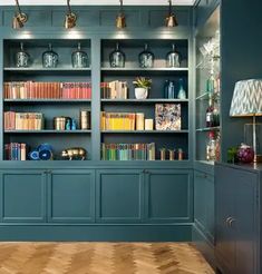 an empty room with many bookshelves and lamps on the shelves in front of them