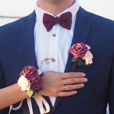 a man in a tuxedo with two boutonnieres on his lapel