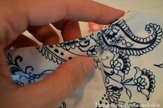 someone is stitching the side of a dress with their hands and sewing it on