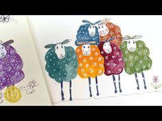 an open book with drawings of sheep on it and the pages are colored in different colors