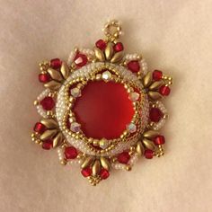 a red and white brooch sitting on top of a table