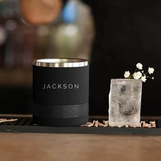 an ice cube next to a blue mug with the word rct on it and a small white flower