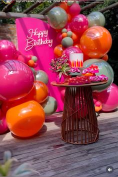 an outdoor birthday party with balloons and cake