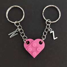 a pink heart shaped keychain with music notes on it and a lego piece in the shape of a heart