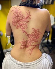 the back of a woman's body with red flowers on her upper and lower back