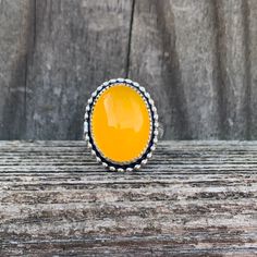 "Simply Bold introduces to you a hand bezel set Chalcedony ring featuring an oval, Yellow Chalcedony stone that is set in a fine silver serrated bezel with a beaded border. These stones are bright yellow and perfect for a bright pop of color! Each stone will vary just slightly in color due to natural stone variances. I used a thick 20 gauge sterling back plate and a thick, hand formed 3.25X1.62mm half round band. This ring has a nice, medium weight to it and is a great everyday ring. Every bezel Unique Handmade Yellow Rings, Handmade Oval Yellow Jewelry, Vibrant Yellow Handmade Jewelry, Vibrant Handmade Yellow Jewelry, Sterling Silver Yellow Cabochon Rings, Yellow Gemstone Ring, Yellow Ring, Bright Pop, Yellow Rings