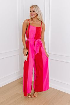 - Step into chic style with this jumpsuit! Its wide-leg silhouette gives it a trendy vibe. Cinched at the waist with a matching belt, it accentuates your figure while providing a flattering silhouette. Whether you are strolling along the boardwalk or attending a summer soirée, this jumpsuit is a chic choice that promises to stand out. - Panels of red and pink hued material - A built-in lining ending at upper-thigh length - A square cut neckline with an elastic back - Adjustable spaghetti straps Chic Red Strapless Jumpsuit For Spring, Chic Wide Leg Jumpsuits For Summer, Chic Wide Leg Jumpsuits And Rompers For Summer, Chic Fitted Pink Jumpsuits And Rompers, Retro Jumpsuit, Chic Pink Jumpsuits And Rompers With Tie Waist, Chic Pink Jumpsuit With Tie Waist, Pink Jumpsuits And Rompers For Spring Day Out, Wide Leg Strapless Jumpsuit For Spring