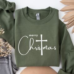 🩴 Merry Christmas Sweatshirt.  Minimalist Christian cross holiday sweater. 🩴 Sizing - See listing image for a specific sizing chart for this style. Please note these are UNISEX style, and therefore have a more relaxed fit. If you are looking for a more fitted look, we suggest sizing down. If you're still unsure, just lay your favorite sweatshirt flat and measure, then compare with the included sizing chart. It's super soft and cozy, you'll love it! 🩴 Gilden Brand Sweatshirts - This classic adult UNISEX crewneck fits like a well-loved favorite. Soft material and quality printing make users fall in love with it over and over again. 🩴 Printing: Our designs are printed with high quality, lasting Direct-to-Garment printing process. This means the pigmented, water-based inks are applied and Minimalist Christmas Shirt, Christian Christmas Sweatshirt, Brand Sweatshirts, Jesus Shirt, Christian Sweatshirt, Minimalist Christmas, Christian Christmas, Family Christmas Shirts, Christian Cross