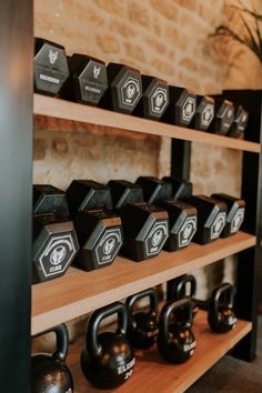 there are many kettles on the shelves in this gym room that is filled with kettles