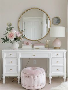 a white desk with a mirror, stool and flowers