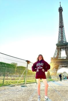 a woman standing in front of the eiffel tower with her hands on her hips