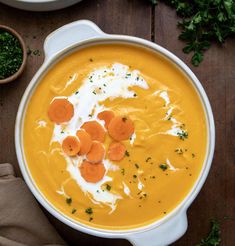 a bowl of carrot soup with yogurt and parsley