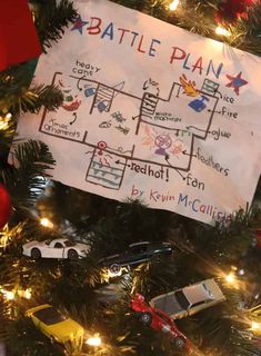 a christmas tree with toy cars and a sign that says battle plan hanging on it