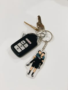 a keychain with an image of a person holding a child and two keys attached to it