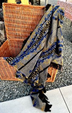 a woven blanket sitting on top of a wicker basket