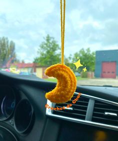 a yellow stuffed animal hanging from the dashboard of a car